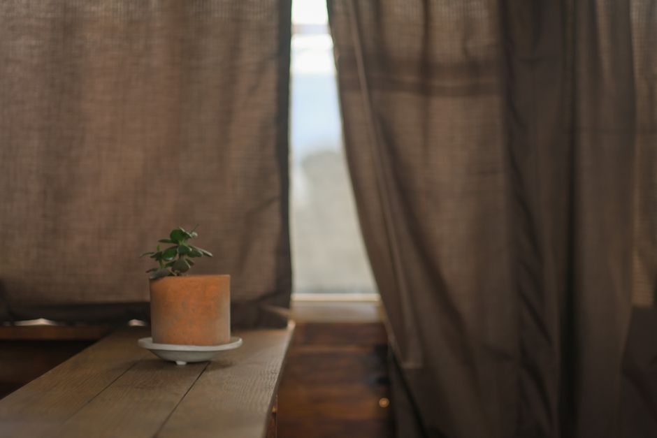 Woonkamer met terracotta gordijnen en planten.